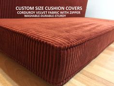 a red couch sitting on top of a wooden floor