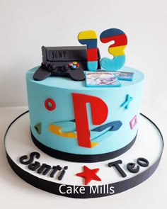 a birthday cake with the letter p on it's side and an image of a video game controller