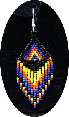 a pair of earrings with multicolored beads hanging from a black hook on a black background