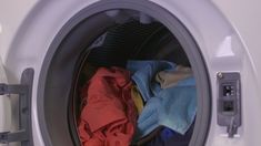 an open washing machine with clothes in it