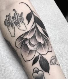 a black and white photo of a flower on the left arm, with hearts in the middle