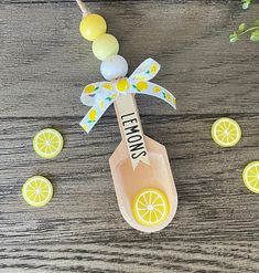 a wooden spoon with lemons hanging from it's side on top of a table