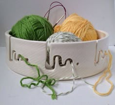 two balls of yarn are in a white bowl