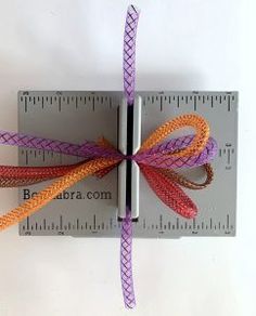 an orange and purple ribbon tied to a ruler