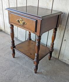 an old wooden table with a drawer on it