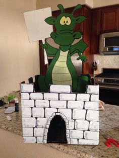 a paper cut out of a green dragon on top of a white brick wall in a kitchen