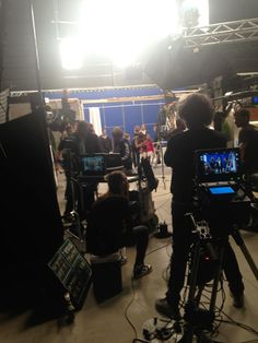 a group of people standing in front of a camera set up for a video shoot