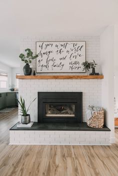 a white brick fireplace with wood floors and a sign above it