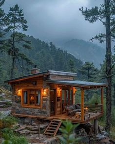 a small cabin in the woods with stairs leading up to it