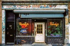 an old brick building with two doors and signs on the front windows that say randy's club light