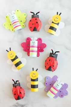 paper crafts made to look like ladybugs and bees on a marble surface with text overlay