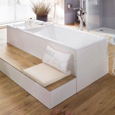 a white bath tub sitting on top of a wooden floor