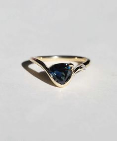 a gold ring with a pear shaped blue diamond