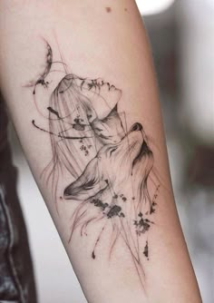 a woman's arm with a tattoo on it that has an image of a wolf