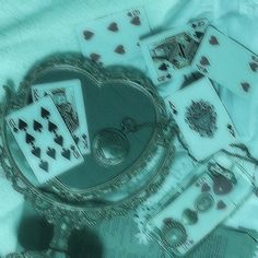 playing cards are laying on top of a table next to a heart shaped mirror and keychain