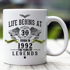 a white coffee mug with the words life begins at 26 born in 1953 and legend