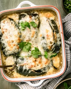 a casserole dish filled with chicken and cheese covered in sauce, garnished with parsley