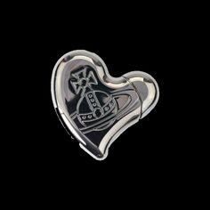 a heart shaped brooch with a boat on it