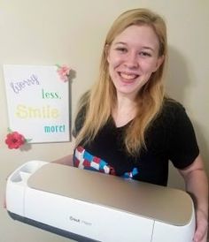 a woman is holding a printer in her hands