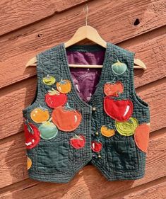 a green vest with apples and cherries on it