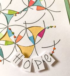 a close up of a greeting card with the words hope on it and colorful shapes