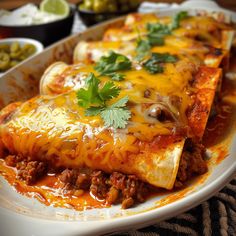 some taco shells are on a plate with sauce and cilantro garnish