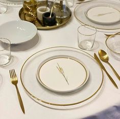 the table is set with white and gold plates