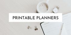 a white desk topped with lots of paperwork and office supplies next to a cup of coffee