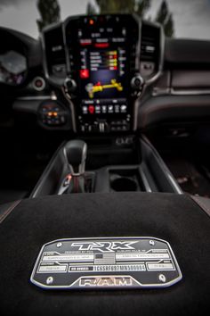 the interior of a car with an electronic display and steering wheel controls on it's center console