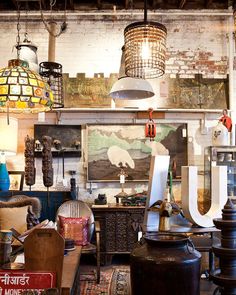 a room filled with lots of furniture and hanging light fixtures on the wall above them