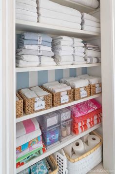 an organized closet with folded towels and baskets