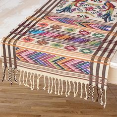 a multicolored rug with tassels on the floor