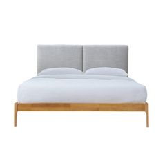 a bed with two pillows on top of it and a headboard made out of wood