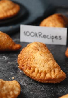 several pastries are on display for sale at a market stall, including one with the word 100k recipes written on it