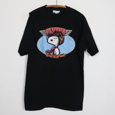 Original 1990s Snoopy Flying Ace Shirt. This is a true vintage shirt, not a modern reproduction. Sizes vary so please use measurements for best idea on fit. No back graphics. Shirt is in good condition, small hole on front, no stains. This shirt comes laundered and ready to wear. Peanuts Shirts Vintage, Ace Shirt, Snoopy Flying Ace, Snoopy Flying, Snoopy Vintage, Rolling Stones Tour, Graphics Shirt, Flying Ace, Rock Shirts