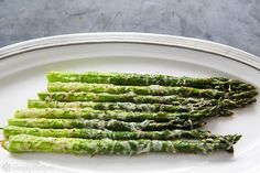 asparagus on a white plate with green sauce