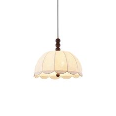 a light hanging from the ceiling with a white shade on it's side and brown trim