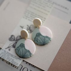 a pair of earrings sitting on top of a piece of paper