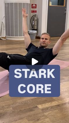 a man laying on top of a pink mat with his arms up in the air