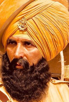 a man with a long beard wearing a turban and gold headdress