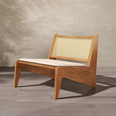 a wooden chair sitting on top of a hard wood floor next to a white wall