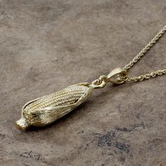 "If she loves the beauty of corn this would be a very unique corn gold necklace gift for her, or for someone who is a member of the corn grower association. This piece is a 14kt gold vermeil corn charm necklace with the corn cob showing in front and the corn husk still tight on the cob. This is a very simple and recognizable ear of corn necklace. I have hand engraved lines on the surrounding corn husk to give it very fine detail and look like actual corn. This is a fully round three dimensional Crop Top Corn Shirt, Indian Corn Earrings, Indian Corn Necklace, Gem Corn, Glass Gem Corn, Ear Of Corn, Corn Cob, Ears Of Corn, Corn Husk