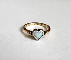 This darling one of a kind ring features a beautiful Australian opal heart which I set in a chunky handmade sterling silver bezel. It sits perched atop a heavy fun round 14k yellow antique reclaimed wedding band, which has an engraving of 9-15-56 along with initials in cursive. I melted two little gold pebbles from scrap and flanked the stone with them. I oxidized the silver bezel to a darker black finish, to contrast with the stone and the yellow gold. One Of A Kind Heart Jewelry For Anniversary, Heirloom Opal Ring With Polished Finish Gift, Heirloom Hallmarked Opal Ring Gift, Unique White Gold Opal Ring Gift, One-of-a-kind Opal Jewelry For Anniversary, Handmade 14k Gold Opal Ring For Anniversary, One Of A Kind Opal Ring For Anniversary, Heirloom White Gold Opal Ring As A Gift, Heirloom White Gold Opal Ring Gift