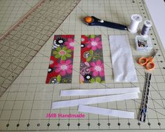 sewing supplies laid out on a cutting board with scissors and tape to cut them into squares