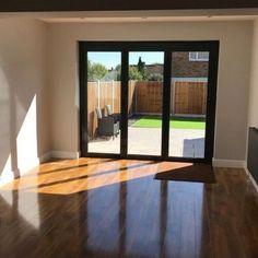 an empty living room with sliding glass doors and hard wood flooring on the outside