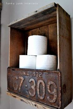 an old wooden box holding several rolls of toilet paper