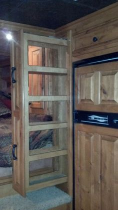 the inside of a wooden cabin with two beds in it and an open door leading to another room