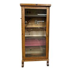 an old wooden cabinet with glass doors on the front and bottom shelves in different colors