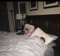 two children sleeping in a bed with white sheets