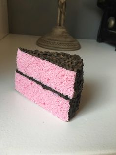 a piece of pink cake sitting on top of a white counter